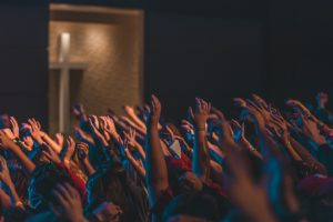 people raising their hands in front of stage